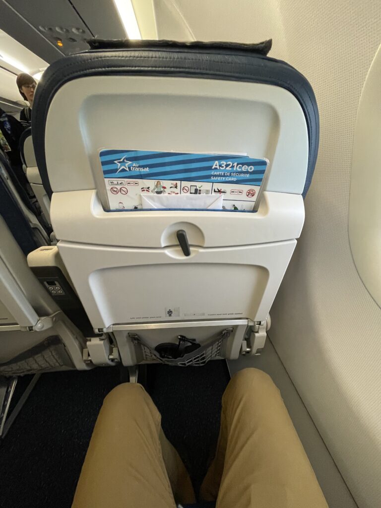 The seatback on the Air Transat A321ceo is equipped with a white tray table and a high literature pocket.