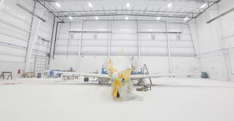 flyExclusive aircraft in an all white hanger.