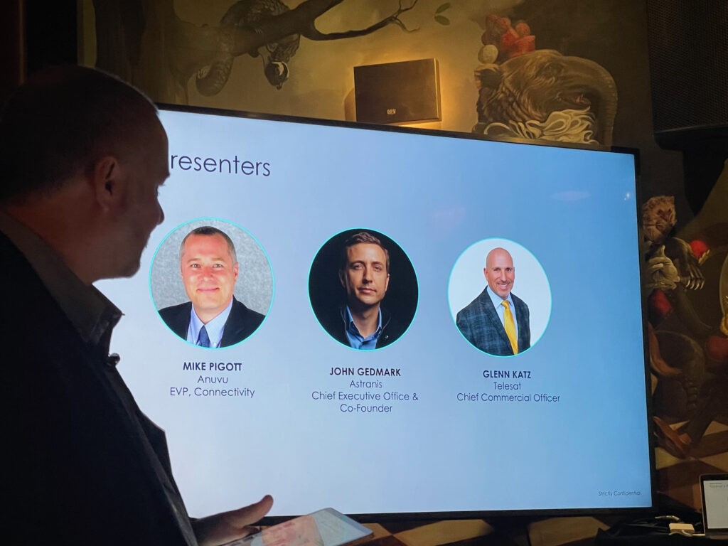 Three executives are shown on a screen: Anuvu's Mike Pigott, Astranis' John Gedmark and Telesat's Glenn Katz