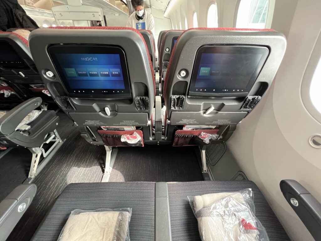 JAL economy class seat is loaded with pockets and includes an embedded IFE screen