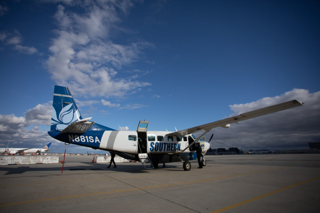 Passengers board the Southern Airways Express Cessna 208 Caravan at Phoenix Sky Harbor on a sunny day.