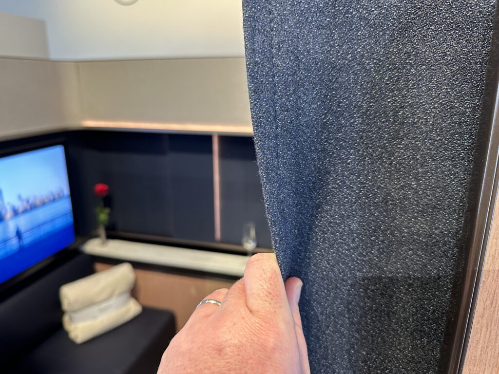 A hand is holding a part of the suite door that is fabric-based and semi-flexible. 