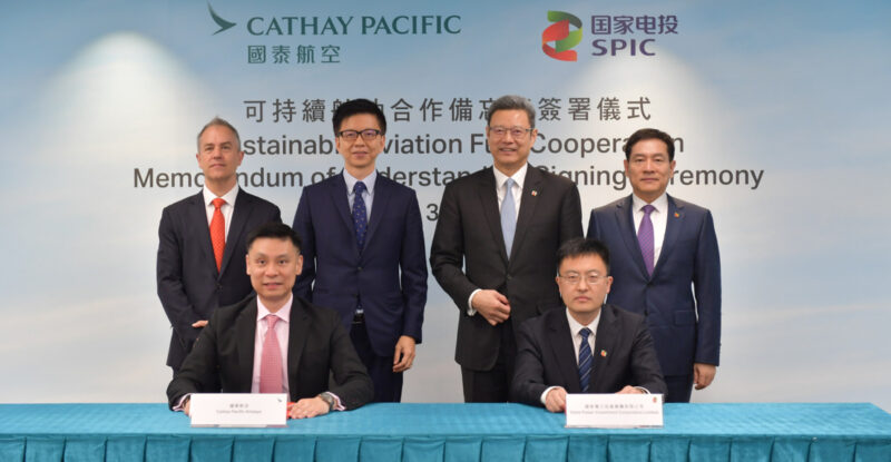 Cathay Pacific Witnessed by SPIC Chairman Qian Zhimin (standing, second from right) and Vice President Chen Haibin (standing, first from right), Cathay Pacific Group Chief Executive Officer Ronald Lam (standing, second from left), and Chief Operations and Service Delivery Officer-designate Alex McGowan (standing, first from left), the MoU was signed by SPIC International Finance (HK) Co. Ltd. Chairman Yin Guoping (seated, right) and Cathay Pacific General Manager Corporate Affairs Andy Wong (seated, left).