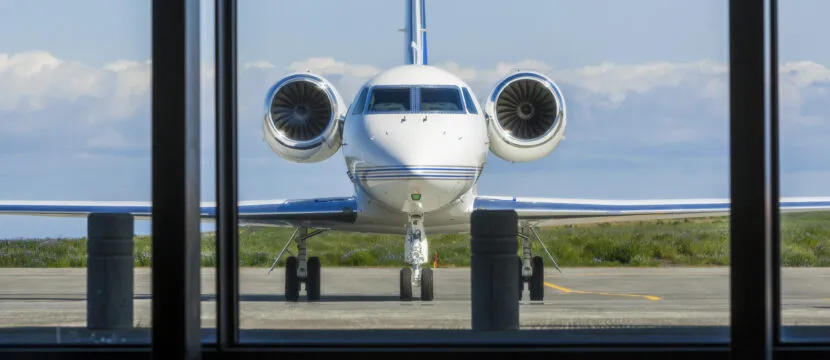 Private business jet, parked at the FBO, as seen through a very large window. BizAv