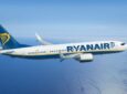 Ryanair aircraft in flight on a clear day over a large open body of water.
