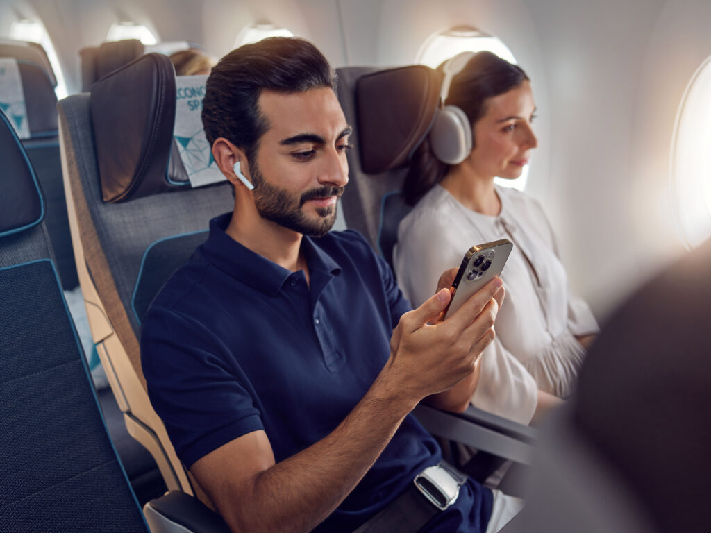 Etihad Airways Economy Class with guest taking advantage of Etihad's unlimited Wi-fly