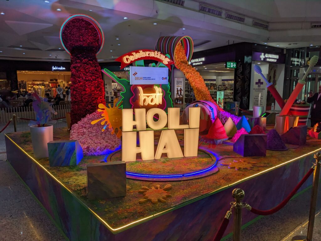 Holi decorations at DEL airport are colorful and lit up.