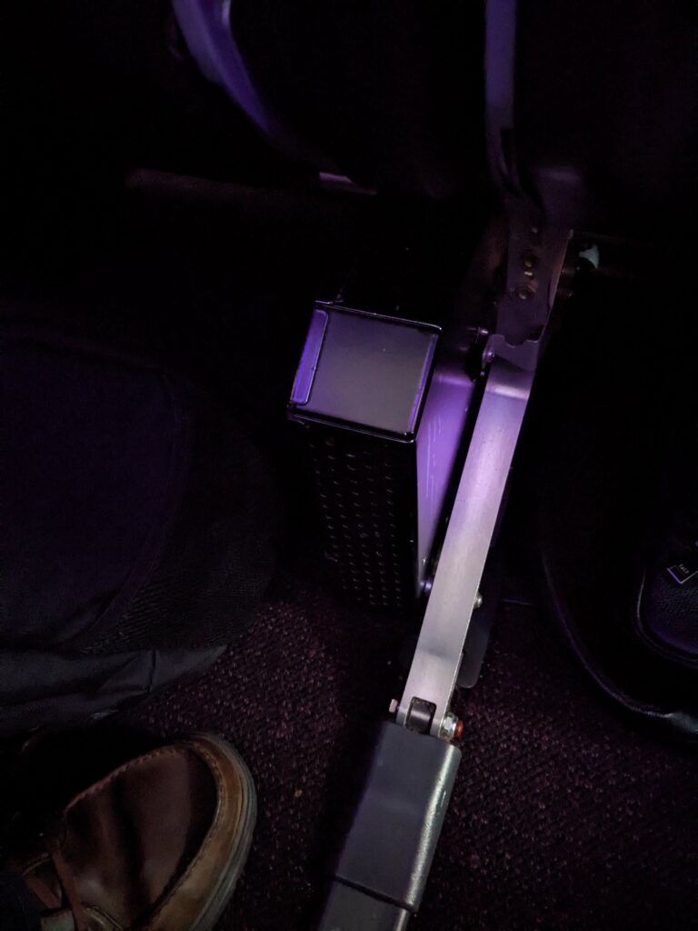 Metal box protruding in middle seat footwell.