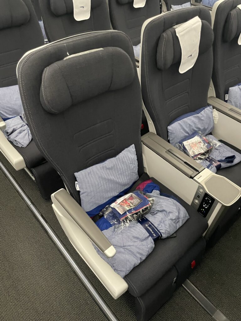 Premium Economy class seats have a blue blanket, blue pillow and amenity kit.