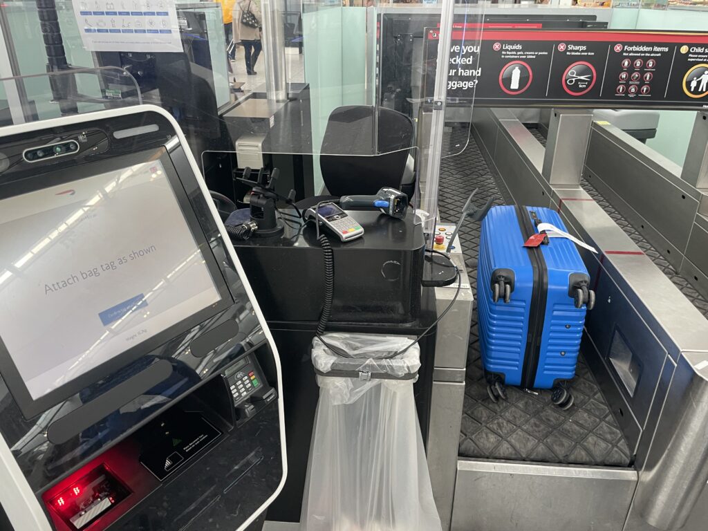 Luggage is placed in the airport's automated bag drop.