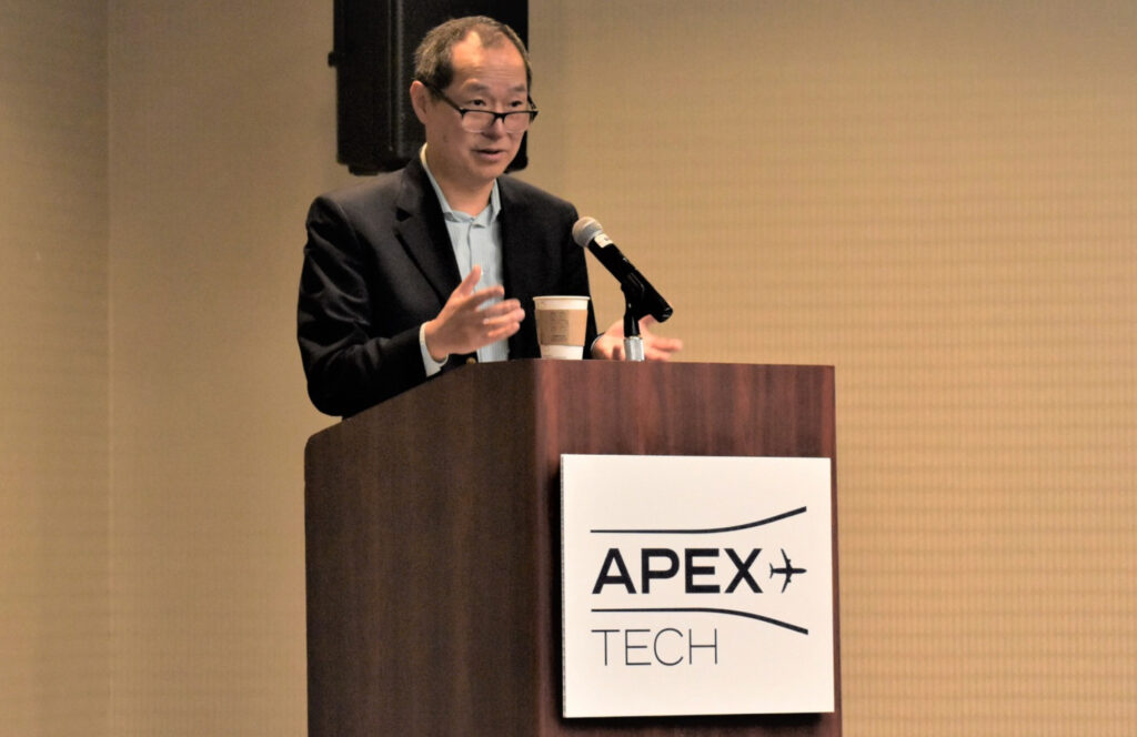 Air China vice president and general manager, North America, Dr. Zhihang Chi at the podium at APEX TECH in Los Angeles