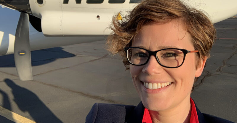 Riona Armesmith, Chief Technology Officer, magniX standing in front of an aircraft on the runway.