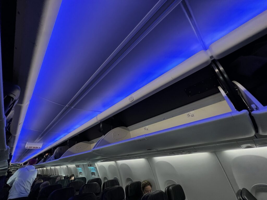 Boeing 737-9000ER featuring the Boeing Sky Interior. The large Space Bins are wide open for passengers as they board the Alaska Airlines aircraft. Blue LED lights cast a nice glow down the length of the cabin.