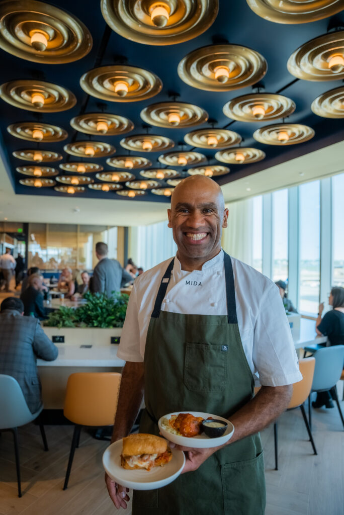 Boston chef Douglass Williams is holding up a dish.