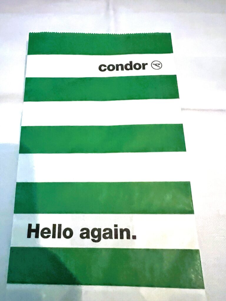 A Condor air sickness bag in green and white stripes.