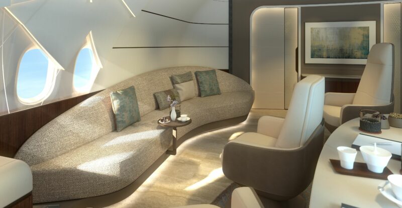 Lounge design for the Lufthansa Technik cabin for the BBJ 777-9. Light streams in from the windows to a calm setting, with a cream colored sofa and other chairs.