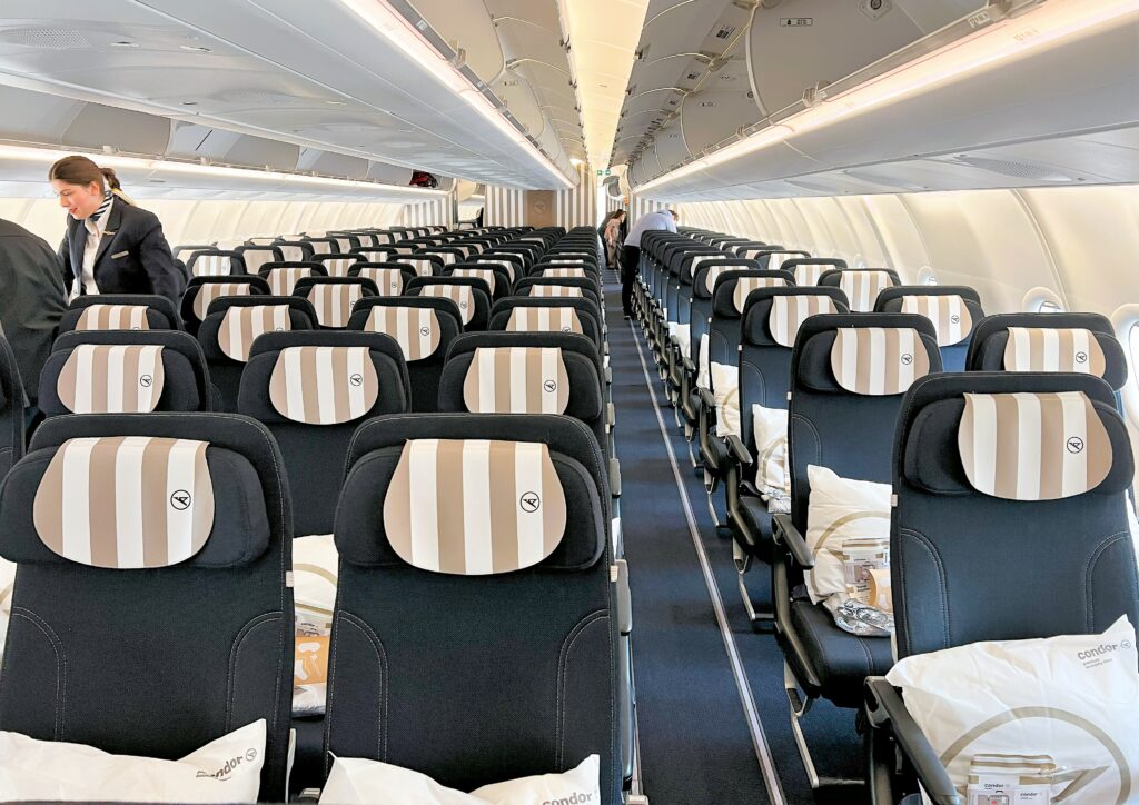 The main economy class cabin is all dark grey with striped sand headrest covers to match the aircraft livery.