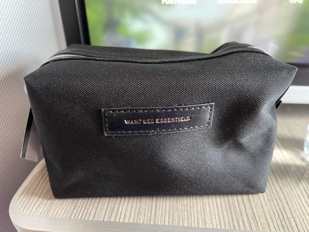 A black amenity kit sits on a table by a window.