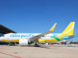 Cebu Pacific A320neo is all white with a yellow tail and yellow and teal lines down the belly of the aircraft.