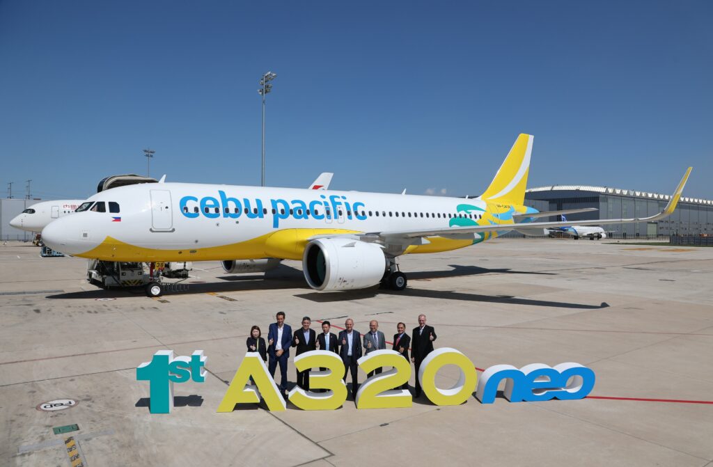 Cebu Pacific A320neo is all white with a yellow tail and yellow and teal lines down the belly of the aircraft.