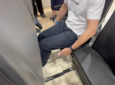 A Recaro employee demonstrates the leg space in the Recaro X-Tend Seat on the AIX show floor.