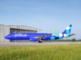 The new JetBlue livery shows a bright blue fuselage with a mixed blue, teal and white square design on it.