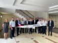 A group of men and women, employees of Lufthansa and Arilink are standing behind a large model of an Airlink Aircraft.