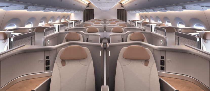 Head on view of Recaro business class seats in a widebody. The seats are greyish in tone with a light brown headrest and detailing.
