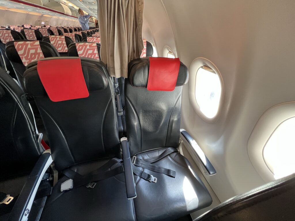 Seats on board the Air France A320 with red headrest flaps.