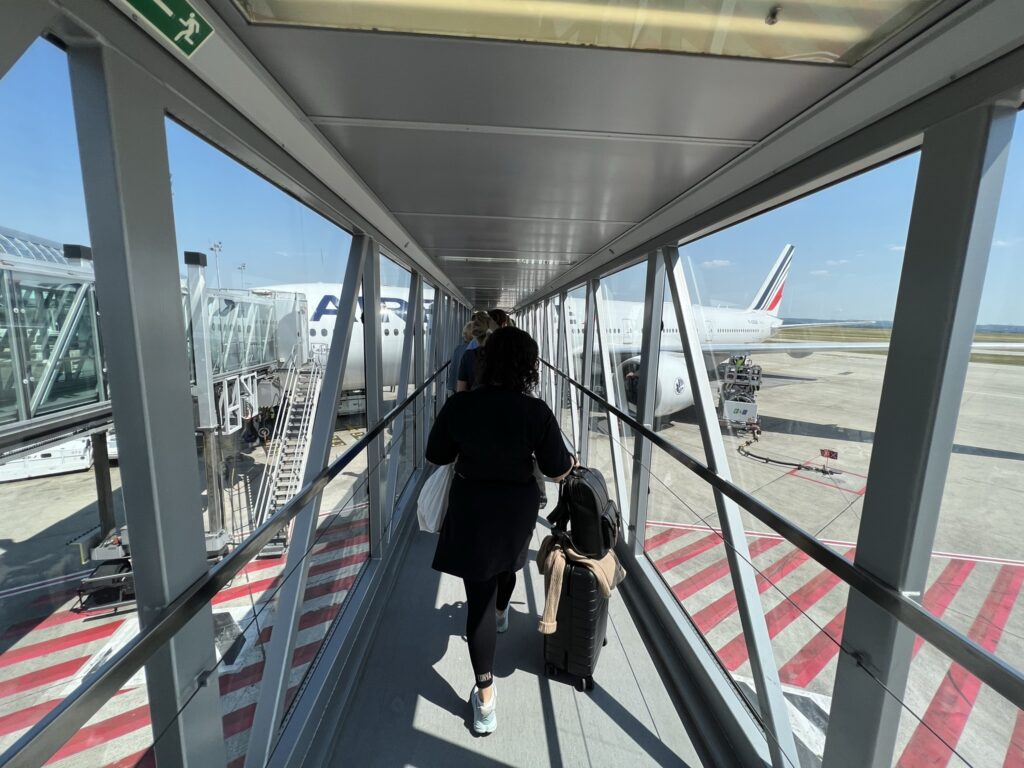 Passengers walking on a glass jet bridge. 