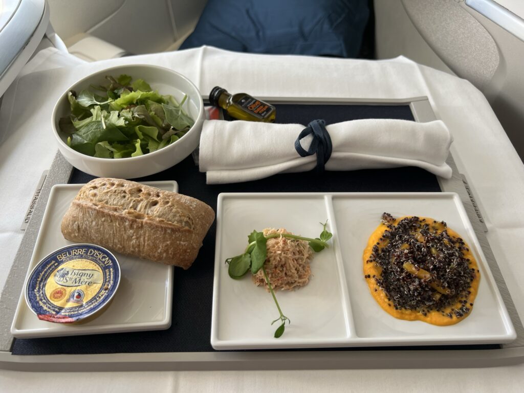 A meal is displayed on the Air France business class seat tray table.