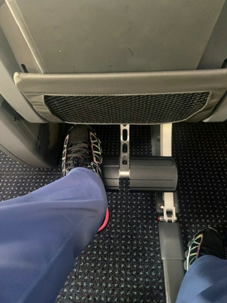 A passenger's foot are seen using the foo rest on the American Airlines 787 premium economy seat.