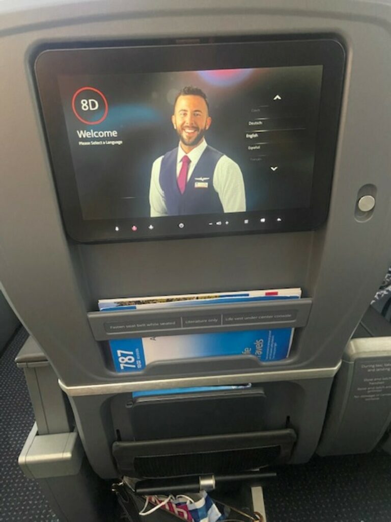 An American Airlines employee is on the IFE screen's welcome page.