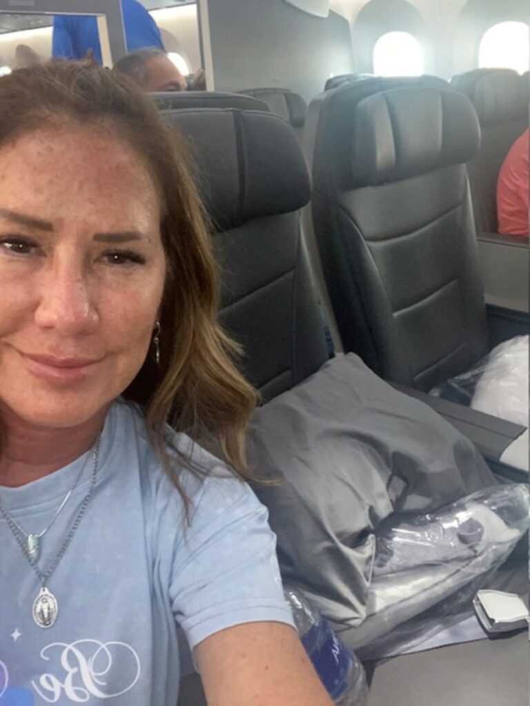 The writer is taking a selfie beside two empty seats on the American Airlines Boeing 787 flight to Venice. 