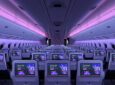 Purple and pink LED lights cascade the length of a widebody aircraft fitted with Panasonic Avionics' Astrova IFE system in economy class.