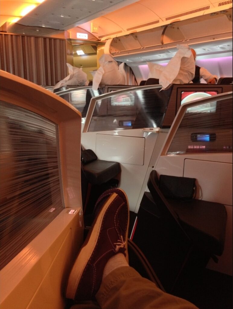 A man's feet are rest on the ottoman in the Virgin Atlantic Dream Suite.