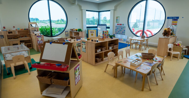 Pittsburgh International Airport childcare center is brightly lit by a large windows. Many toys fill the room.