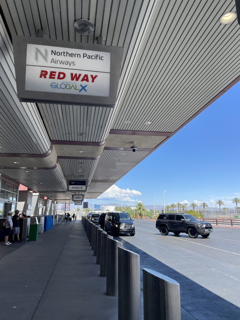 Airport signage showing the drop-off point for passengers flying Northern Pacific Airways and Red Way.