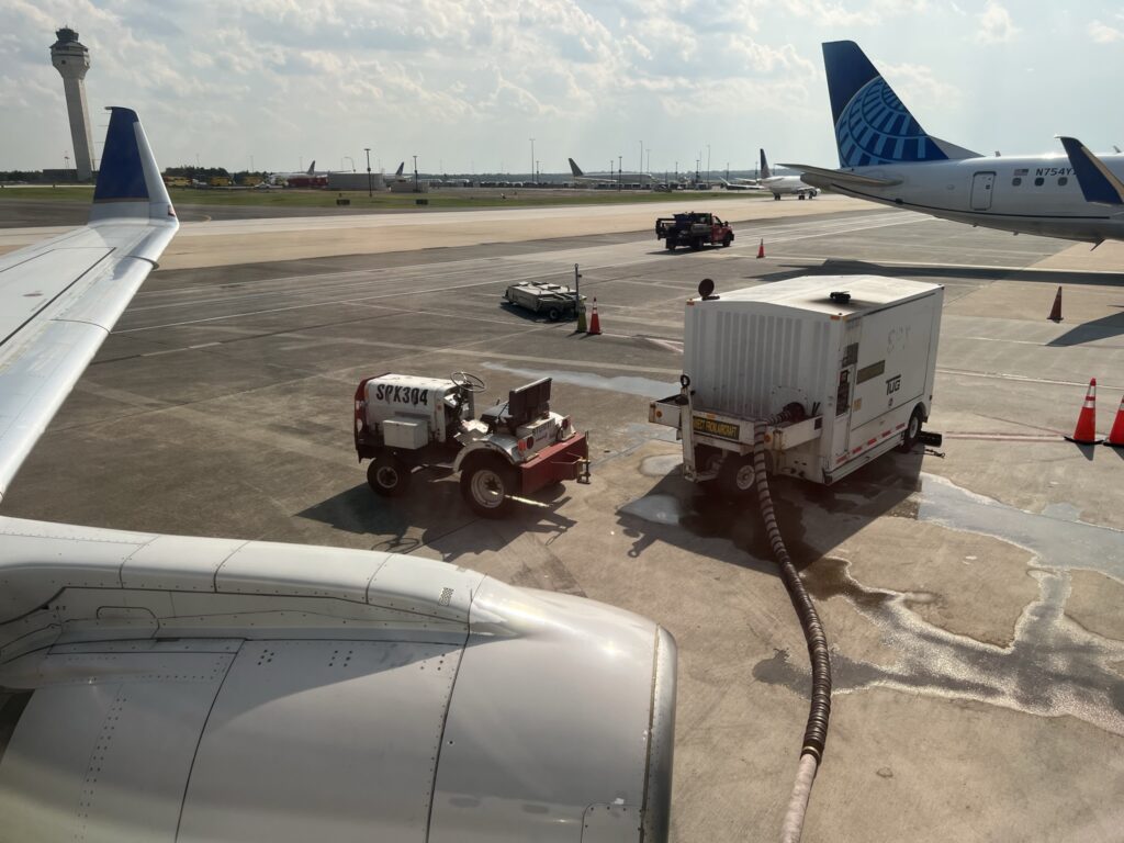 Ground crew working outside of the United ERJ175 to cool it down.