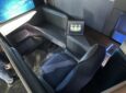 Recaro business class seat demonstrator R Horizon. The sensor-laden seat is lit with blue LEDs and a small display with green notifications sits to the side.