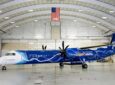 An Alaska Airlines Q400 with ZeroAvia livery on it. The aircraft sits in the hanger.