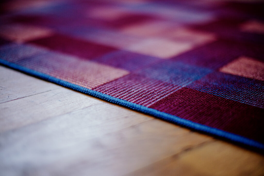 A close up of the woven square motif in purples, reds and other colours.