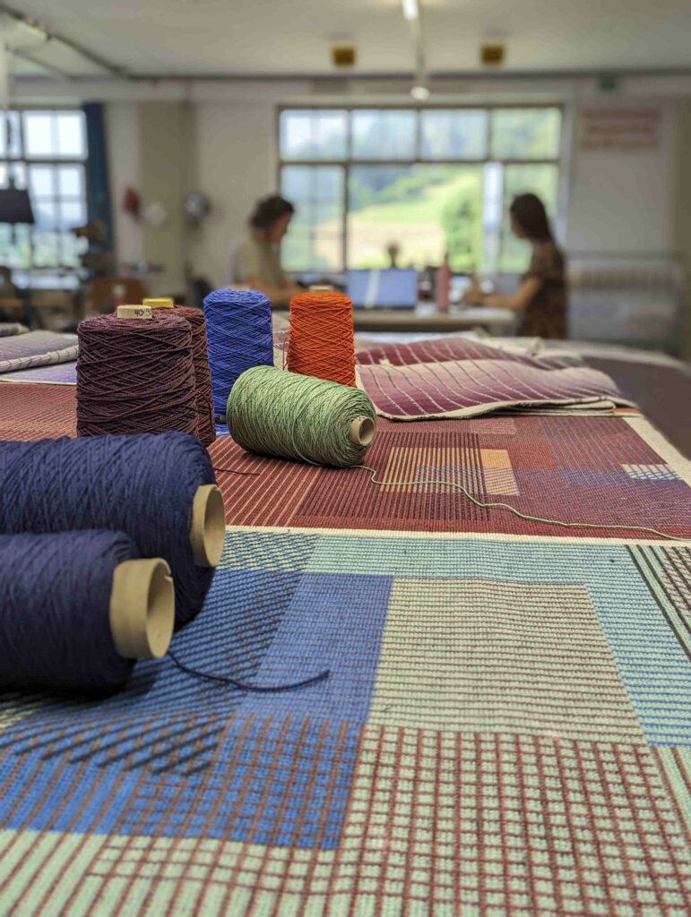 Various fabrics and threads are pictured while people are in the process of designing the PG-Lantal product.