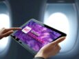 Spafax AdConnect has a bright purple landing page on a persons tablet in flight.