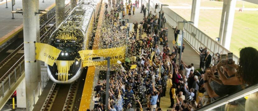 A crowd of people celebrate the opening of the new Brightline route in Orlando.