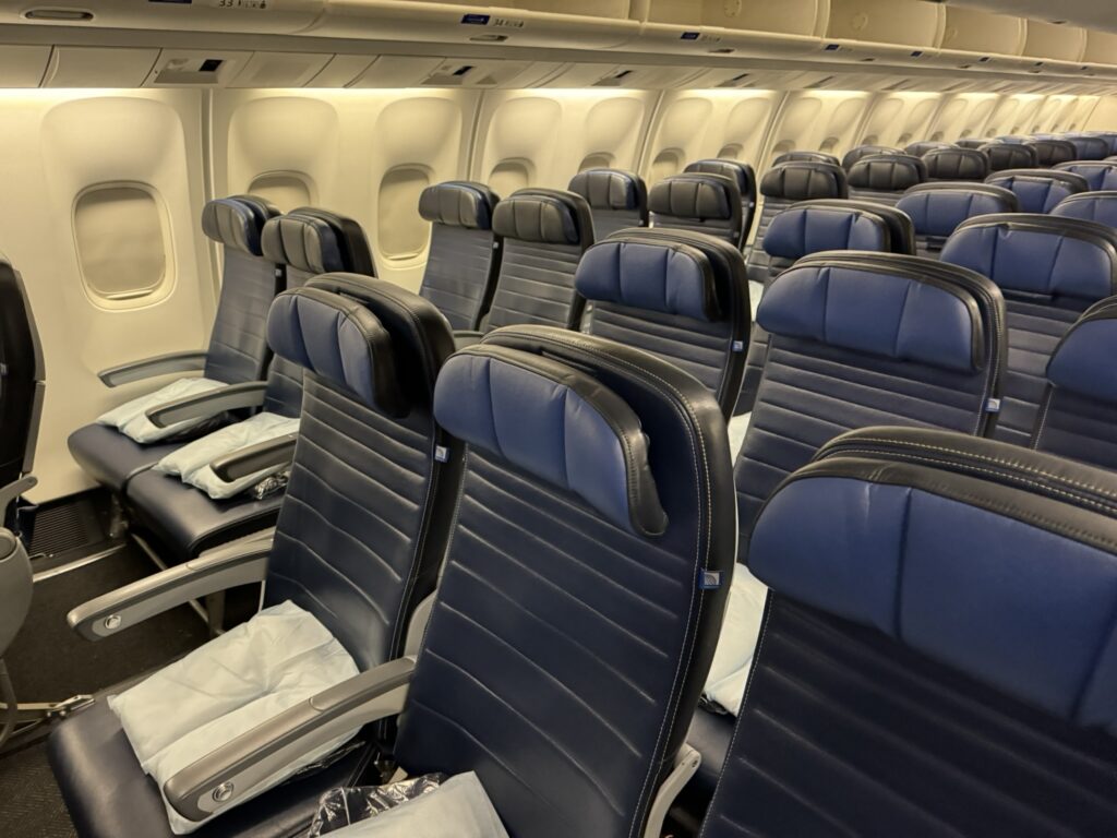 Rows of United economy class seats in blue with headrests.