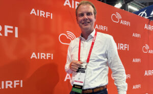 AirFi founding partner and CEO Job Heimerikx is pictured in front of an AirFi step & repeat at the APEX/IFSA Global EXPO in Long Beach.