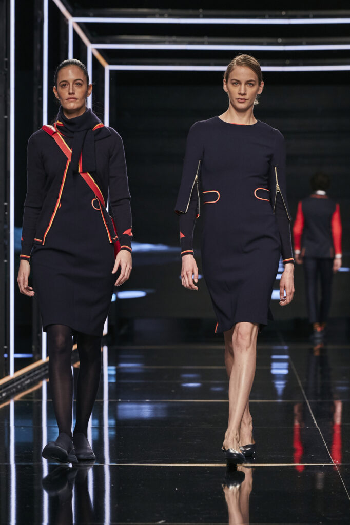 Two female crew members are modeling Iberia's new uniforms on the runway