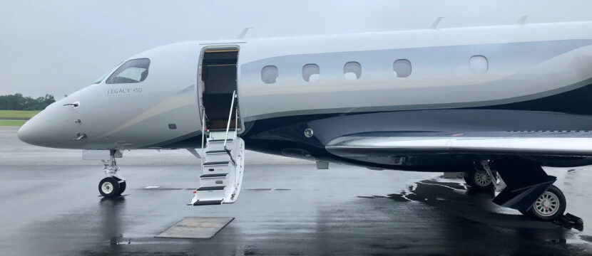 Embraer Legacy 450 parked and ready to board on a rainy day. ATG antenna installed on the underbelly.