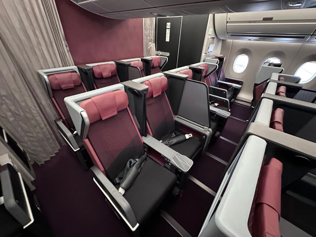 JAL A350 premium economy cabin is striking with a burgundy base but a mixture of colors including various greys, charcoal and coral.